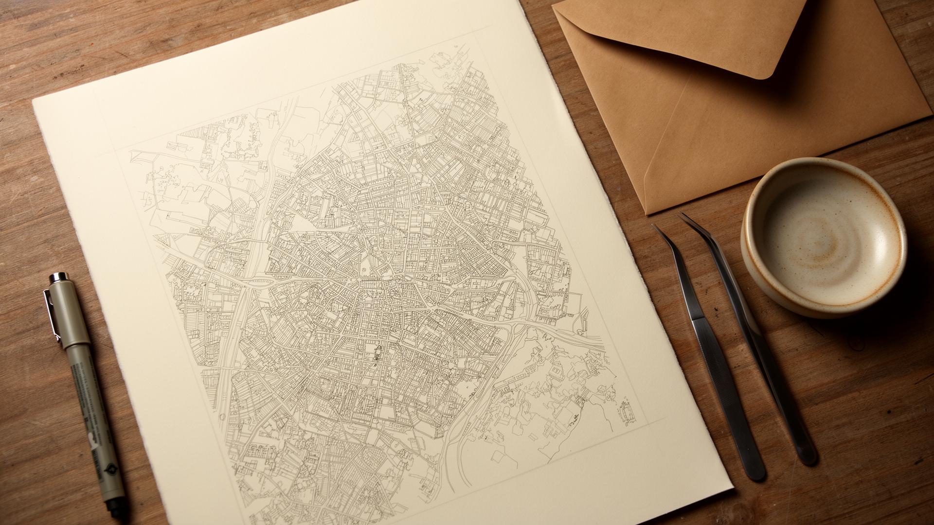 Finished plotted map beside a pen, ceramic dish and kraft envelope.